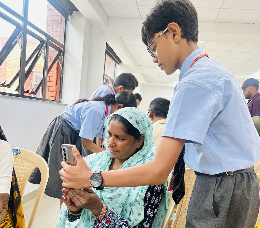 Digital Gurukul: a student teaching a woman from the village to use her own phone at Birla Open Minds International School, Bhopal